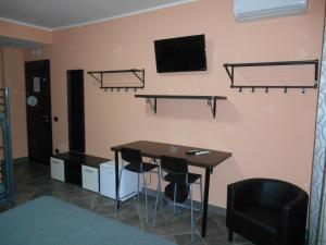Zimmer mit einem Schreibtisch und einem TV an der Wand in der Unterkunft B&B Mazzini in Battipaglia