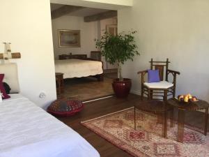 uma sala de estar com uma cama, uma mesa e cadeiras em Maison de village Novissime em Noves