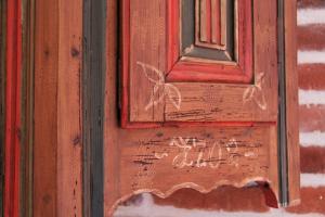 d'une porte en bois avec une fenêtre portant un écriteau. dans l'établissement Le Pommenial de la Hérissonnière, à Saint-Aubin-de-Bonneval
