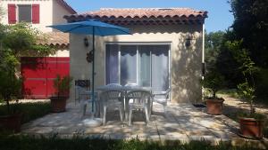 un patio con mesa, sillas y sombrilla en Villa Mylena, en Jouques