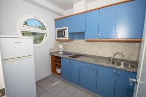 una cocina con armarios azules y fregadero en Servatur Terrazamar Sun Suite, en Puerto Rico de Gran Canaria