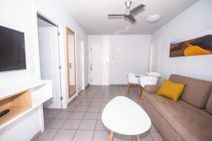 a living room with a couch and a tv at Servatur Terrazamar Sun Suite in Puerto Rico de Gran Canaria