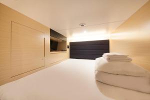 uma sala de estar com um pufe de feijão branco em Tabist CapsuleHotel APODS Himeji Station em Himeji