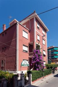 a red brick building with a purple tree at Hotel Villa Rosa in Sestri Levante