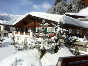 a house covered in snow with snow covered trees at Wagner Häusl in Saalbach-Hinterglemm