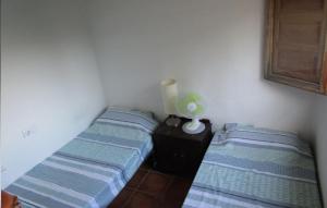 グラナダにあるCasa Ken Holiday Homeのベッド2台、ランプ1台が備わる客室です。