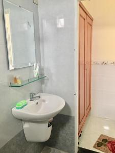 W łazience znajduje się biała umywalka i lustro. w obiekcie Triệu Hoàng Hotel w mieście Quy Nhơn
