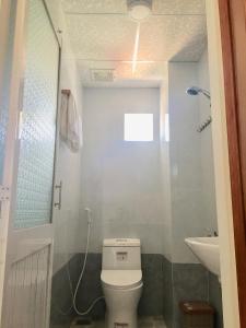 małą łazienkę z toaletą i umywalką w obiekcie Triệu Hoàng Hotel w mieście Quy Nhơn