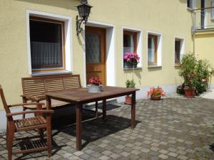 una mesa de madera y un banco en un patio en Ferienhof Jungkunz en Schwarzenbach am Wald