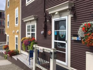 a brown house with a door and flowers on it at The Narrows B&B in St. John's