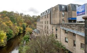 um edifício ao lado de um rio ao lado de um edifício em Britannia Edinburgh Hotel em Edimburgo