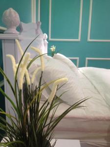 a white bed with a plant in front of it at Baling Mountain Garden Village in Baling