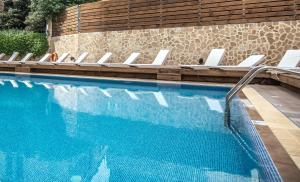 a swimming pool with a row of lounge chairs next to it at Rhodos Horizon Blu-Adults Only in Rhodes Town
