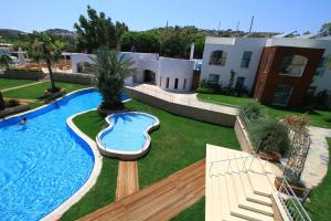 a swimming pool in a yard next to a building at Costa Luvi Hotel Bodrum - All Inclusive in Gümbet