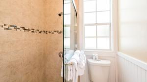 a bathroom with a shower with a toilet and a window at L'Habitation Guesthouse- Adult Exclusive in Key West