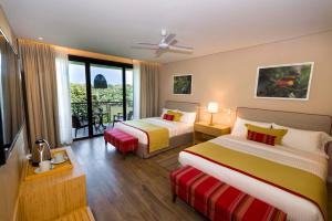 a hotel room with two beds and a balcony at Iguazu Jungle Lodge in Puerto Iguazú +37 photos