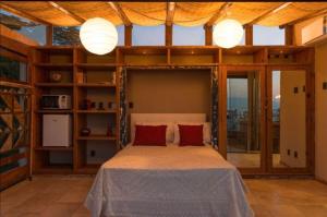 a bedroom with a large bed with red pillows at Mansion Aline in Rio de Janeiro