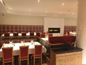 a restaurant with tables and chairs and a fireplace at Appartements zur Rose in Steinach am Brenner