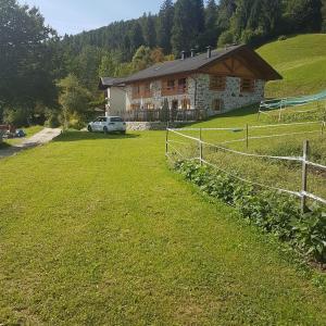 dom na wzgórzu z ogrodzeniem i trawnikiem w obiekcie Chalet Lagorai w mieście Roncegno