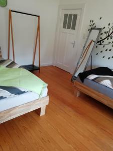 a bedroom with two beds and a wooden floor at Ferienwohnung"Zur Birke" in Winsen