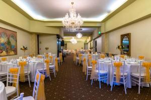 une salle de banquet avec des tables blanches et des chaises bleues dans l'établissement Casa Siqua, à Bucarest