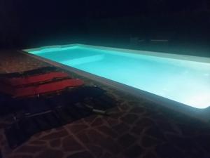 a swimming pool at night with red chairs around it at Casaletto In Maremma a Magliano in Magliano in Toscana