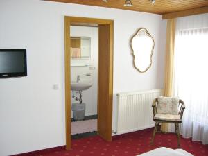 a bathroom with a sink and a mirror and a chair at Haus Helga in Brand