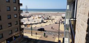 een groep mensen die op het strand lopen in de buurt van een gebouw bij Studio Casinoplein Middelkerke in Middelkerke