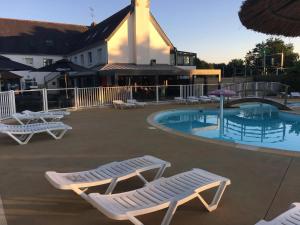 a group of lounge chairs and a swimming pool at Camping Kost Ar Moor in Fouesnant