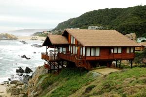 a house on a hill next to the ocean at Shamrock Cottage in Eersterivierstrand