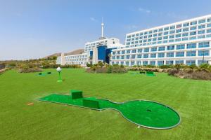 un grande campo verde di fronte a un grande edificio di Grand Luxor Hotel a Benidorm