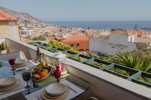 een tafel met een fruitschaal op een balkon bij Colina Mar in Funchal