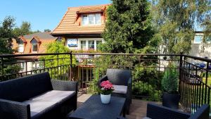 a balcony with a couch and a table with flowers at Apartament Lawenda in Łeba
