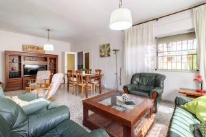 uma sala de estar com sofás e uma mesa em Chalet acogedor con piscina muy cerca de Granada em Churriana de la Vega