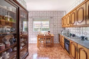 una cocina con armarios de madera y una mesa. en Chalet acogedor con piscina muy cerca de Granada, en Churriana de la Vega