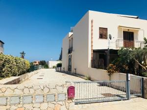 una calle frente a un edificio blanco en Appartamento BluOltreMare, en San Vito lo Capo