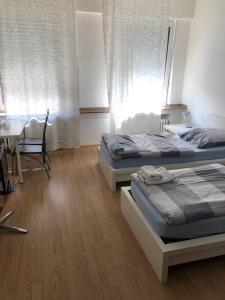 two beds in a bedroom with a table and a dining room at Hotel Europa in Mönchengladbach