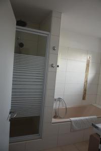 オルデンブルクにあるschönes Apartment mit Dachterrasseのバスルーム(バスタブ、鏡付きシャワー付)