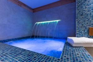 a large blue tub with a shower in a bathroom at Punta Margherita in Valtournenche