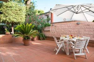 un tavolo e sedie con ombrellone su un patio di B&B La Quercia a Pescara