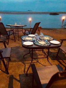a table and chairs on the beach at night at C Beyond Nilaveli in Nilaveli