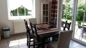 a dining room with a table and chairs and a window at Gästehaus Luck in Ditzum