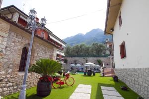 a green yard with a red bike in a building at Albergo Casa Este in Brenzone sul Garda