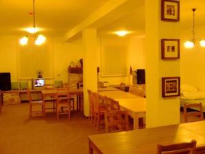 a dining room with tables and chairs and a television at Magdolna Vendégház in Szögliget