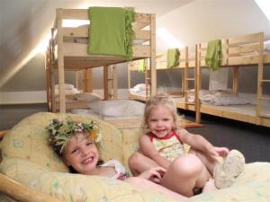 duas meninas sentadas numa cama num quarto com beliches em Magdolna Vendégház em Szögliget