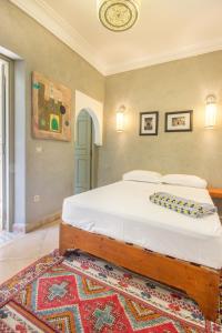 a bedroom with a large bed with a rug at Riad Privé De Luxe Au Coeur De La Kasbah Avec Hammam in Marrakesh