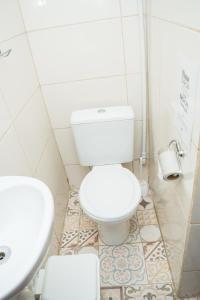 a white toilet sitting in a bathroom next to a sink at Mambembe Hostel in Rio de Janeiro