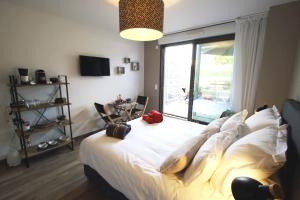 a bedroom with a large white bed with a large window at Sweet Home studio Aix en Provence, terrasse, piscine, resto, in Aix-en-Provence