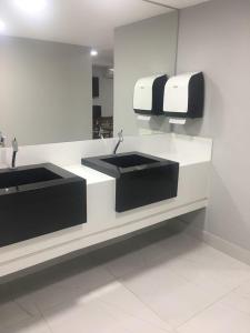 La salle de bains est pourvue de 2 lavabos et d'un miroir. dans l'établissement Hotel Oásis de Patos, à Patos