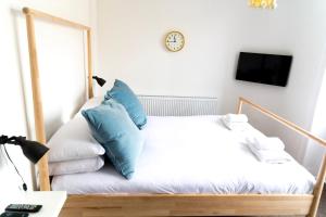 a bedroom with a bed with blue pillows at The Black Fox in Bath